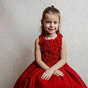 Candice a rejoint le concours — aidez-le/la à gagner de superbes lots ! child, girl, red_dress, smile, portrait, sitting, hands, long_hair, happy, cute, indoor, wall, texture, fashion, person, youth, innocence, beauty, elegant, casual
