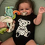 baby, bear_design, black_clothing, child, colorful, comfort, cushion, cute, happy, indoor, infant, lying_down, onesie, pacifier, plush_toy, portrait, smiling, soft_toys, toddler, toy