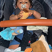 Ilyess a rejoint le concours — aidez-le/la à gagner de superbes lots ! baby, baby_toy, blanket, child, closeup, clothing, comfort, cute, hat, headwear, indoor, infant, pacifier, person, plush_toy, seatbelt, sitting, soft_toy, stroller, toy