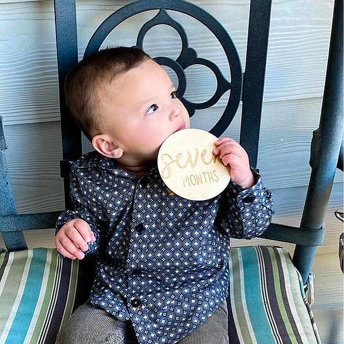 Beckham joined the competition — help win amazing prizes! baby, biting, chair, clothing, coat, cushion, cutlery, face, food, furniture, head, homedecor, jacket, jeans, pants, person, photography, portrait, sitting, spoon