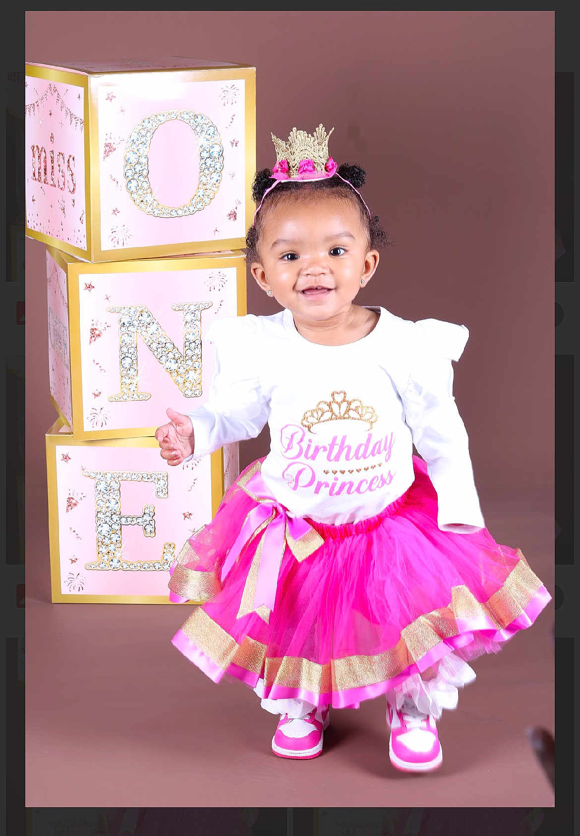 Phoenix is registered to the contest to win money with this photo: toddler, birthday, princess, pink_tutu, crown, blocks, one, smiling, child, studio, portrait, celebration, happy, fashion, footwear, white_shirt, gold_accents, cute, fun, posing