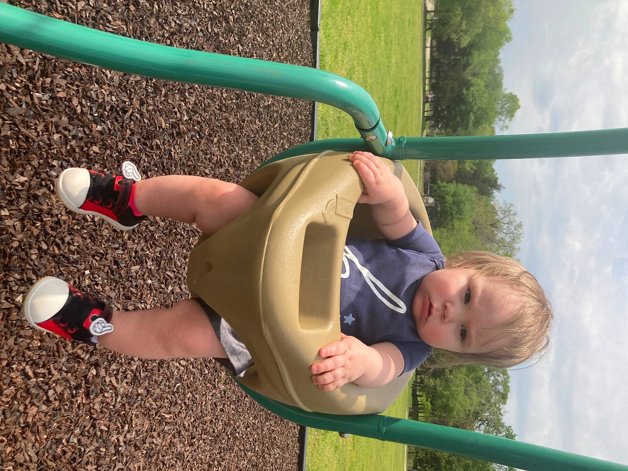 Justin is registered to the contest to win money with this photo: baby, baby_toddler_clothing, child, city, elbow, foot, fun, grass, human_leg, knee, leisure, outdoor_play_equipment, people_in_nature, person, play, recreation, sky, thigh, toddler, toy