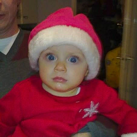 Gabby is registered to the contest to win money with this photo: baby, cheek, child, christmas, christmas_eve, face, fictional_character, head, headgear, headwear, holiday, person, santa_claus, smile, toddler