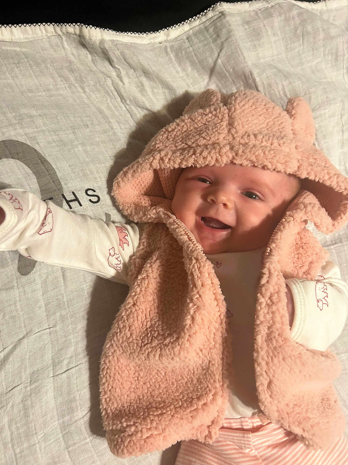 Ellena joined the competition — help win amazing prizes! baby, infant, smile, hood, pink, vest, clothing, lying_down, fabric, pattern, cute, happy, child, portrait, face, apparel, soft, warm, newborn, eyes