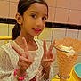 Jasleen participe au concours pour gagner de l'argent avec cette photo : child, girl, smiling, peace_sign, ice_cream, waffle_cone, bracelet, earrings, lace_clothing, table, plate, tiled_wall, indoor, food, dessert, happy, person, portrait, colorful, casual