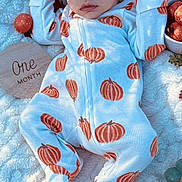 Waylon is registered to the contest to win money with this photo: baby, infant, sleeping, onesie, pumpkin_pattern, blanket, autumn_leaves, decorations, soft_light, shadow, face, hand, footed_pajamas, cuteness, peaceful, newborn, seasonal, cozy, closeup, portrait