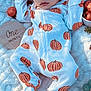 baby, infant, sleeping, onesie, pumpkin_pattern, blanket, autumn_leaves, decorations, soft_light, shadow, face, hand, footed_pajamas, cuteness, peaceful, newborn, seasonal, cozy, closeup, portrait