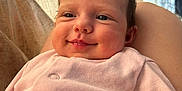 Myla is registered to the contest to win money with this photo: baby, infant, smile, face, clothing, pink, person, indoors, curtain, soft_light, cute, newborn, portrait, happy, skin, head, baby_clothes, room, comfort, rest