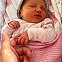 Myla is registered to the contest to win money with this photo: newborn, baby, hand, finger, blanket, pink, sleeping, hat, bed, bedding, heart_pattern, infant, tenderness, soft, cute, person, closeup, rest, comfort, love