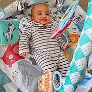 Evan David a rejoint le concours — aidez-le/la à gagner de superbes lots ! animal_print, baby, baby_gym, child, colorful, cute, floor, hanging_toy, happy, indoors, infant, lion_toy, lying_down, play_mat, playtime, smiling, soft_toys, striped_onesie, toy, zebra_toy