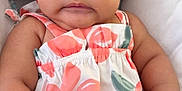 Ailani joined the competition — help win amazing prizes! baby, infant, child, face, portrait, dress, floral_pattern, cushion, seat, arm, hand, skin, expression, eyes, hair, bracelet, red, cute, indoors, closeup