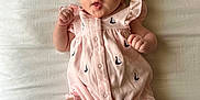 Jerzy is registered to the contest to win money with this photo: baby, infant, child, pink_outfit, headband, bow, sailboat_pattern, lying_down, bed, white_sheet, fists, legs, feet, cute, portrait, indoors, soft_lighting, newborn, sleepwear, expression