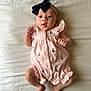 baby, infant, child, pink_outfit, headband, bow, sailboat_pattern, lying_down, bed, white_sheet, fists, legs, feet, cute, portrait, indoors, soft_lighting, newborn, sleepwear, expression