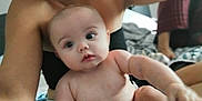 Keitah is registered to the contest to win money with this photo: baby, infant, child, person, skin, face, arm, hand, torso, indoor, blurred_background, adult, holding, curious, wide_eyes, chubby_cheeks, soft_light, bed, blanket, casual