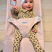 Kaia joined the competition — help win amazing prizes! baby, infant, child, smiling, beanie, hat, bouncer, babybjorn, leopard_print, onesie, harness, wooden_floor, rosy_cheeks, big_eyes, hand, feet, indoor, seat, cozy, portrait