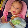 Chloe joined the competition — help win amazing prizes! baby, infant, car_seat, blanket, pink_cushion, face, child, smile, blue_eyes, clothing, seatbelt, indoor, cute, portrait, young_child, sitting, soft_texture, warm, comfort, adorable