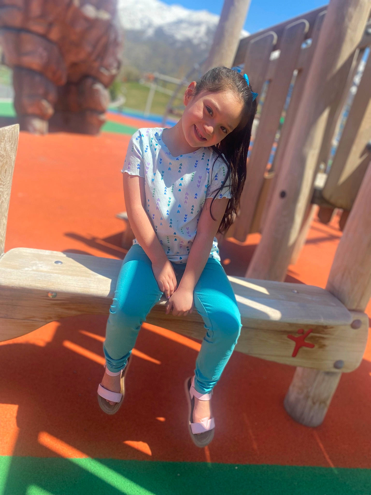 Aviona is registered to the contest to win money with this photo: city, electric_blue, eyewear, flooring, fun, happy, human_leg, joy, knee, leisure, outdoor_play_equipment, person, play, recreation, sandal, sitting, sky, smile, t_shirt, thigh