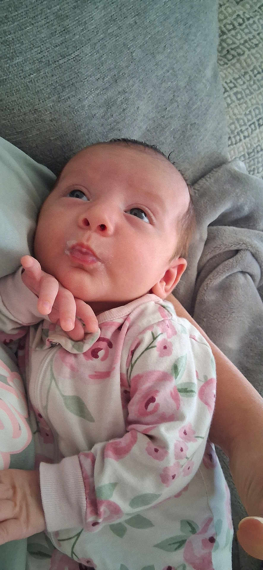 Lily is registered to the contest to win money with this photo: baby, infant, face, hand, onesie, floral_pattern, blanket, person, skin, cute, newborn, sleepwear, expression, comfort, soft, closeup, portrait, indoors, resting, cozy
