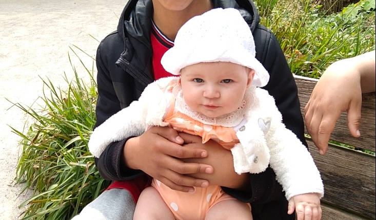 Inaya a rejoint le concours — aidez-le/la à gagner de superbes lots ! baby, baby_toddler_clothing, cap, child, dress, eye, face, finger, fun, gesture, grass, hand, happy, hat, head, headwear, people_in_nature, person, plant, skin