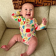 Adelaine Faythe is registered to the contest to win money with this photo: baby, infant, smiling, couch, onesie, seashell_pattern, starfish_pattern, happy, child, indoor, furniture, blanket, cheerful, cute, playful, skin, sitting, expression, home, portrait