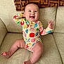 baby, infant, smiling, couch, onesie, seashell_pattern, starfish_pattern, happy, child, indoor, furniture, blanket, cheerful, cute, playful, skin, sitting, expression, home, portrait
