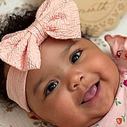 Amanda joined the competition — help win amazing prizes! baby, infant, smiling, pink_bow, headband, floral_dress, tongue_out, cute, cheeks, lying_down, patterned_blanket, 6_months_sign, happy, portrait, closeup, face, child, adorable, indoor, soft_lighting