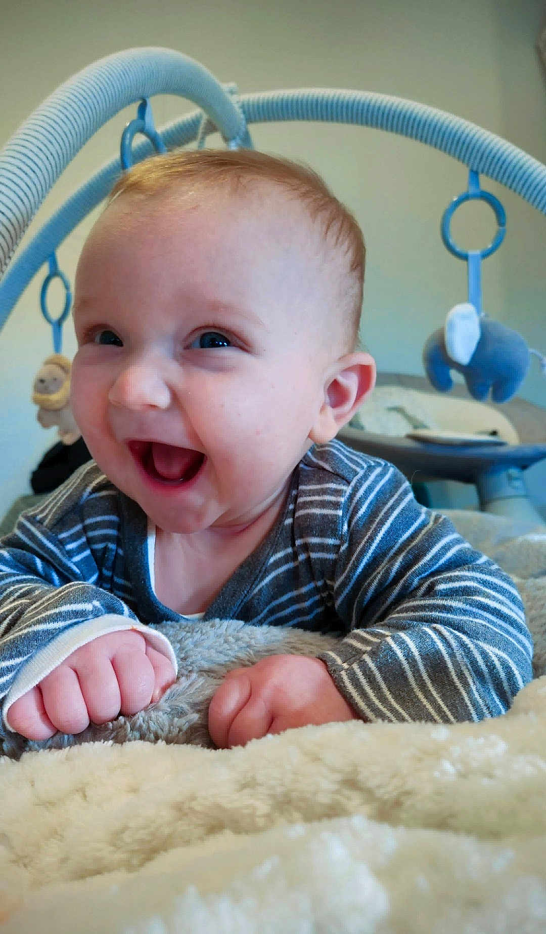 Elijah is registered to the contest to win money with this photo: baby, baby_gym, baby_toys, blanket, child, closeup, cute, face, hands, happy, indoor, infant, playtime, portrait, smiling, soft_texture, striped, striped_clothing, toys, young_child