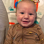 Bennett joined the competition — help win amazing prizes! baby, smiling, face, onesie, brown_clothing, bird_pattern, infant, child, cute, happy, portrait, indoor, cartoon_monkey, rainbow, background, seated, young_child, closeup, expression, bright_eyes