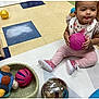 toddler, child, indoor, playroom, toy, ball, colorful, pink, floor_tile, rug, basket, wooden_shelf, footwear, sitting, expression, reflection, play, clothing, young_child, cute