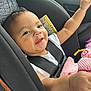 Xaviera is registered to the contest to win money with this photo: baby, car_seat, child, infant, seat_belt, pink_blanket, toy, happy, smiling, arm_raised, cute, indoor, vehicle, child_safety, portrait, close_up, seat, clothing, face, skin