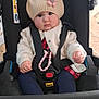baby, baby_accessory, beaded_bracelet, blue_pants, car_seat, child, clothing, cute, face, floor, flower, hat, indoor, infant, jacket, person, pink_shoe, portrait, seatbelt, sitting