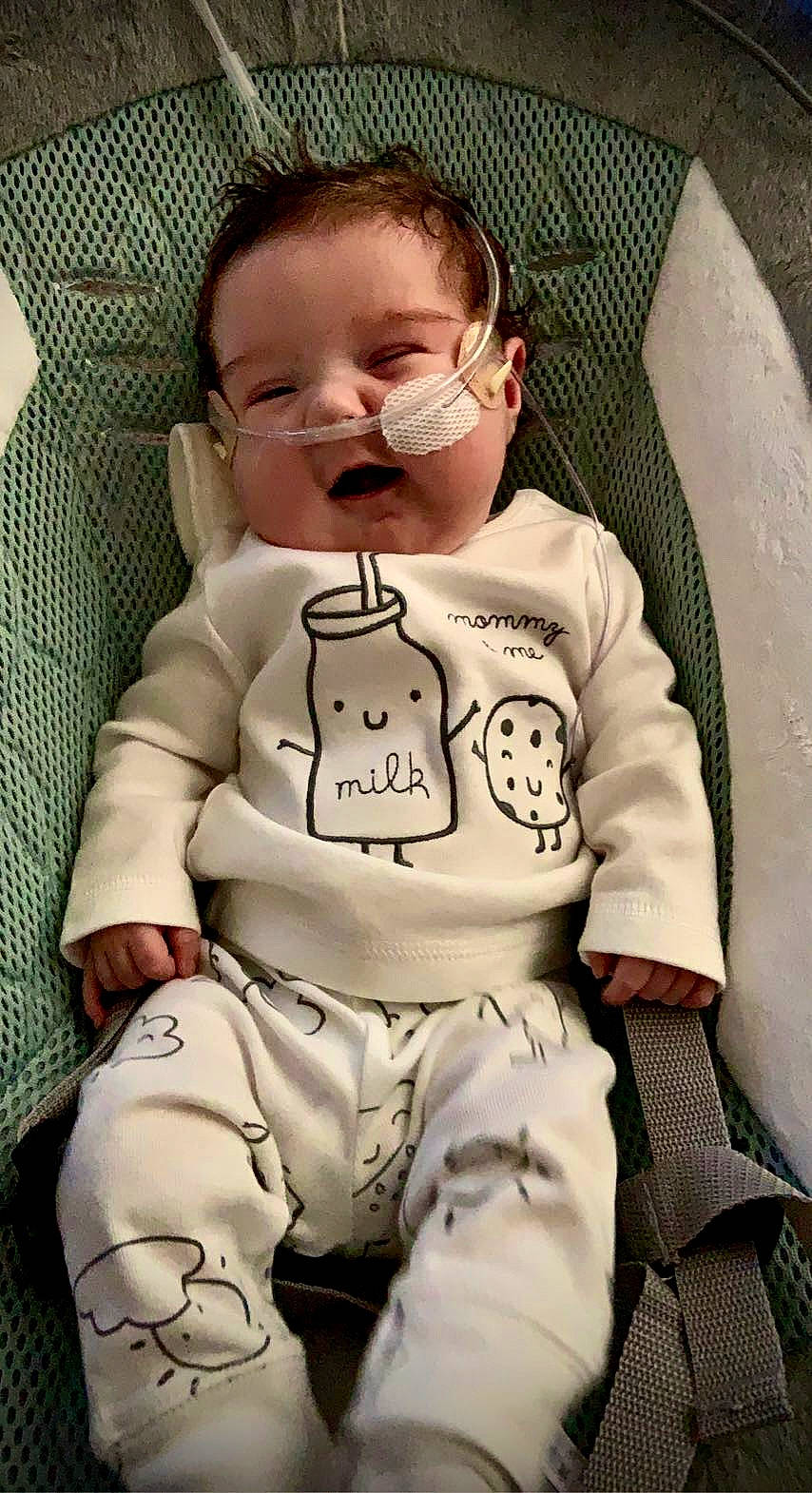 Ivy is registered to the contest to win money with this photo: arm, baby, baby_products, baby_toddler_clothing, cheek, child, comfort, eyewear, hand, happy, head, human_body, nose, outerwear, person, personal_protective_equipment, sitting, skin, sleeve, smile