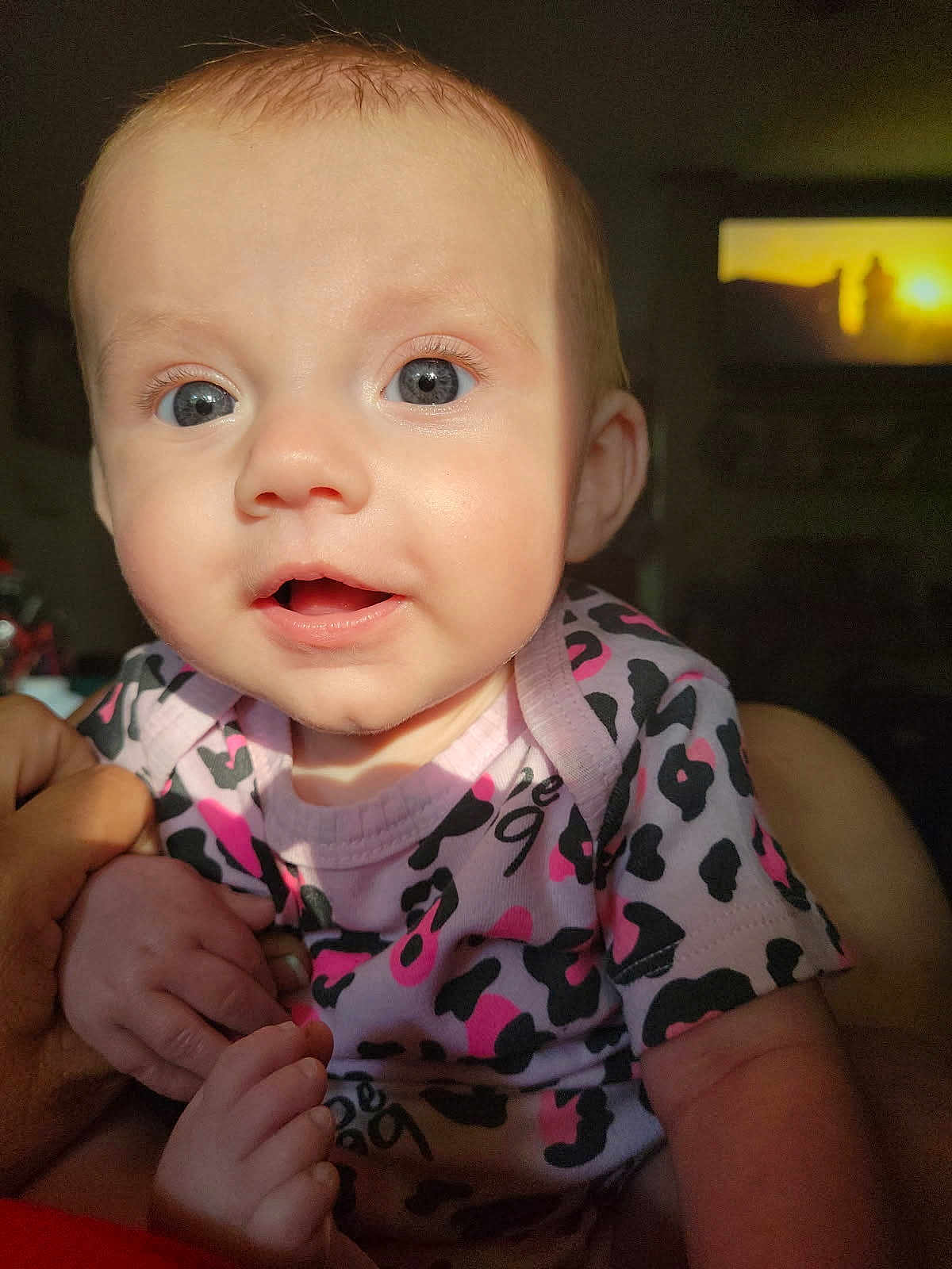 Jane joined the competition — help win amazing prizes! baby, infant, child, close_up, blue_eyes, pink_onesie, patterned_clothing, hand_holding, sunlight, indoor, portrait, cute, soft_skin, expression, tiny_fingers, newborn, person, face, eye_contact, young_child