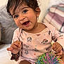 baby, toddler, smiling, happy, child, indoors, toy, colorful, ball, face, hair, clothing, pajamas, pattern, bed, cushion, person, cute, playful, young