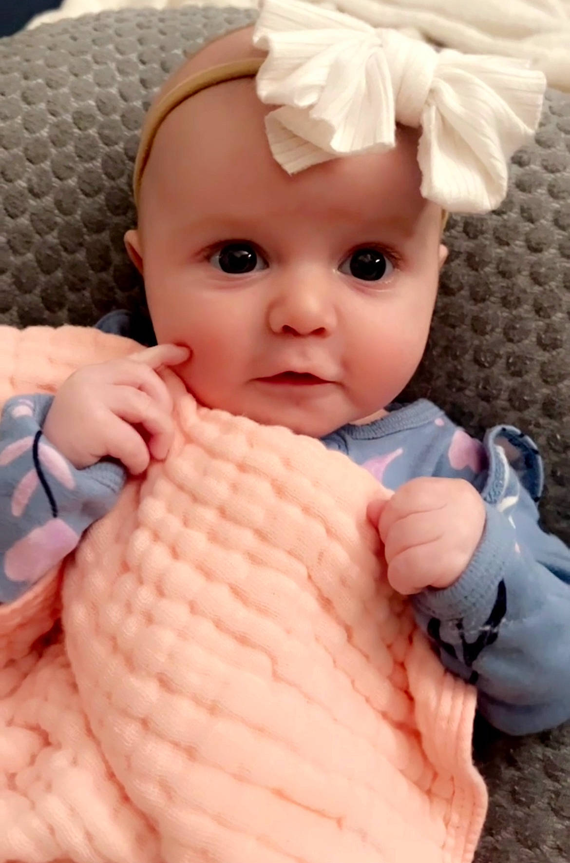 Lyla is registered to the contest to win money with this photo: arm, baby, baby_toddler_clothing, cheek, child, chin, eye, eyelash, finger, gesture, headwear, nail, neck, nose, person, pink, skin, sleeve, textile, thumb