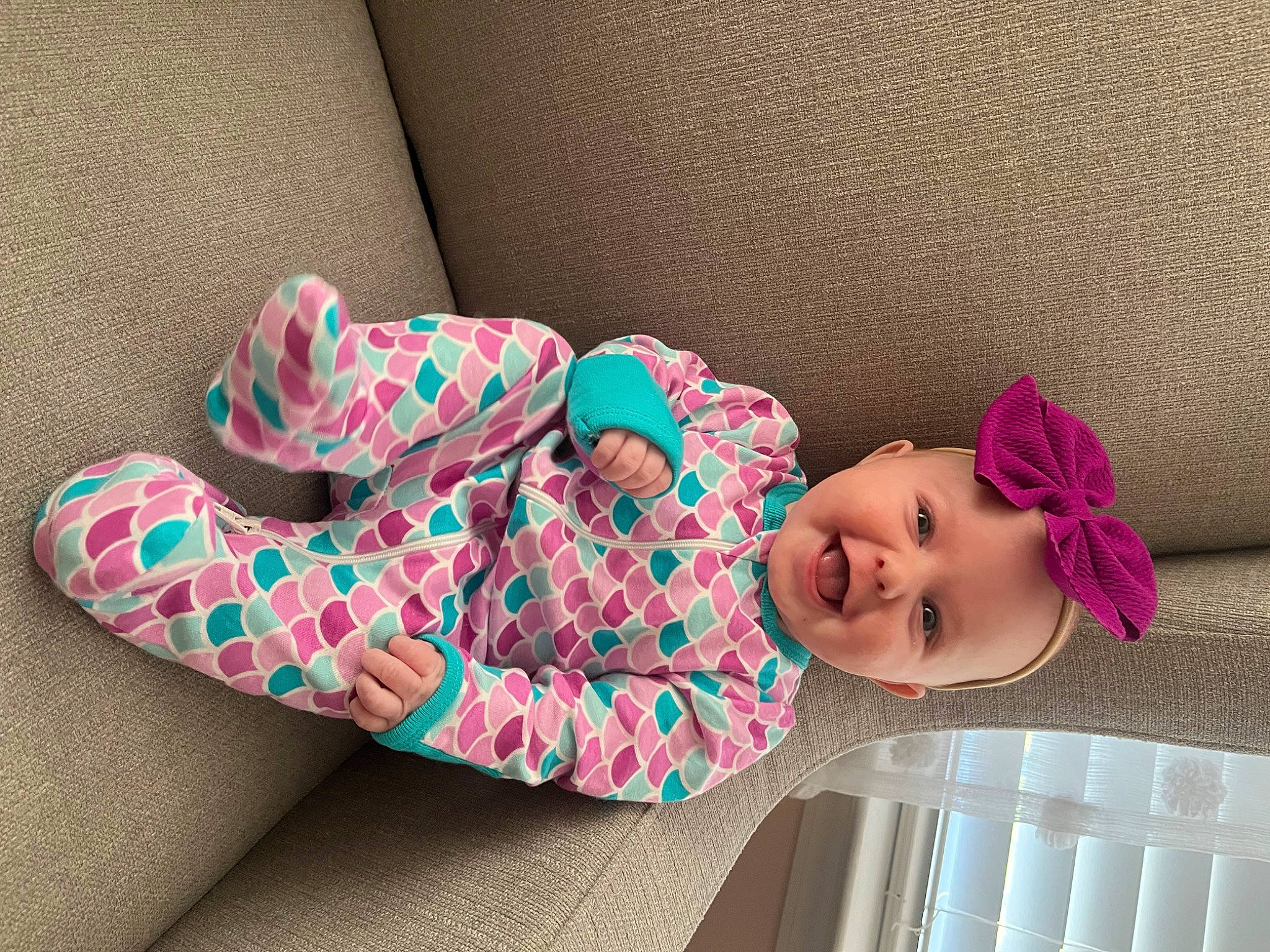 Lyla is registered to the contest to win money with this photo: arm, baby, baby_toddler_clothing, child, comfort, couch, dress, eye, hand, headwear, human_body, human_leg, leg, linens, magenta, pattern, person, pink, sleeve, textile