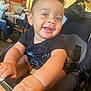 baby, smile, hands, stroller, indoor, restaurant, people, man, table, chair, drink, clothing, face, person, happy, child, casual, background, light, curly_hair