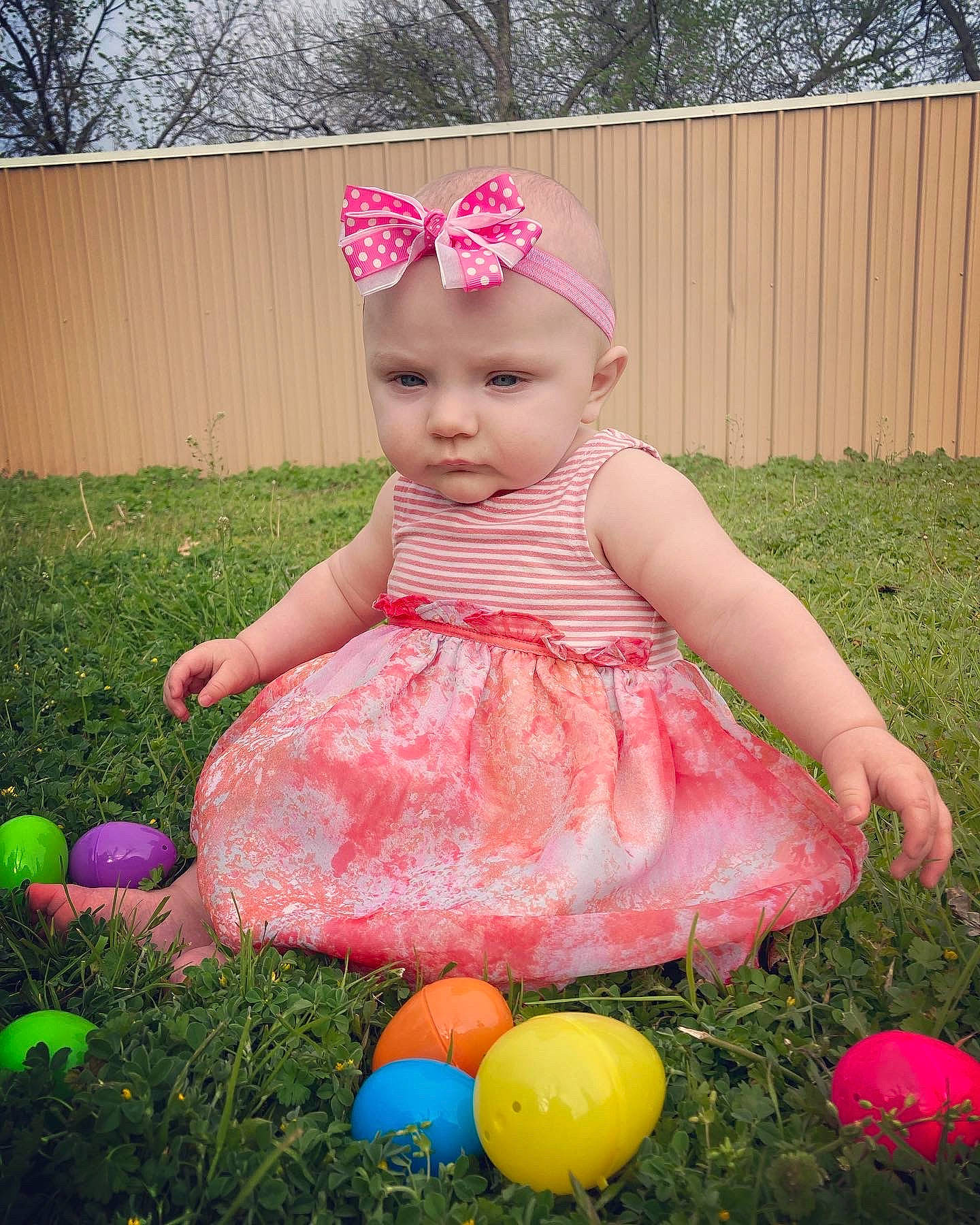 Kreia is registered to the contest to win money with this photo: baby, baby_toddler_clothing, child, dress, face, fence, fun, grass, happy, headwear, lawn, leisure, magenta, pattern, people_in_nature, person, pink, plant, recreation, summer