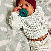 Abria joined the competition — help win amazing prizes! baby, blanket, child, comfortable, cute, face, feather_pattern, hand, headband, indoor, infant, knitted_outfit, lying_down, newborn, pacifier, portrait, relaxed, sleepwear, soft_texture, white_clothing
