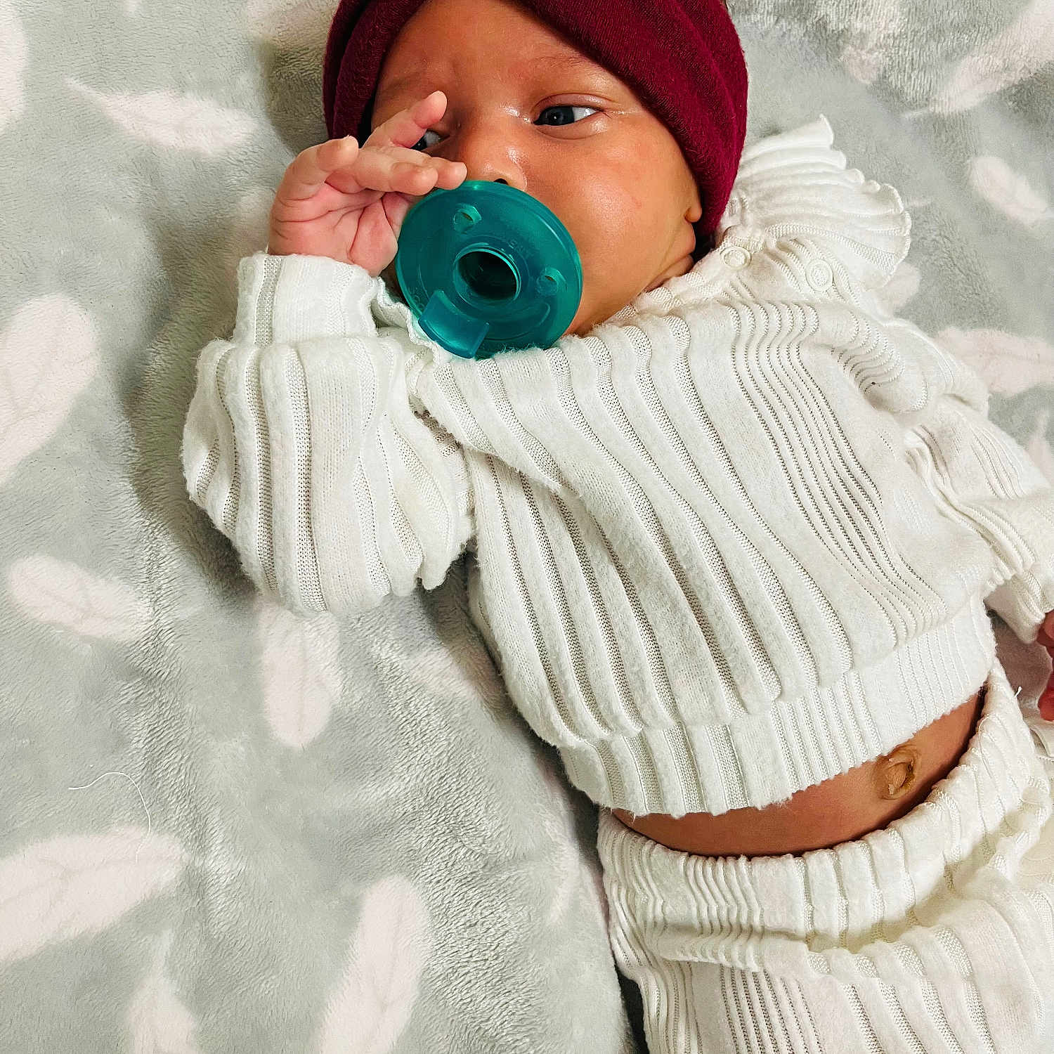 Abria joined the competition — help win amazing prizes! baby, blanket, child, comfortable, cute, face, feather_pattern, hand, headband, indoor, infant, knitted_outfit, lying_down, newborn, pacifier, portrait, relaxed, sleepwear, soft_texture, white_clothing