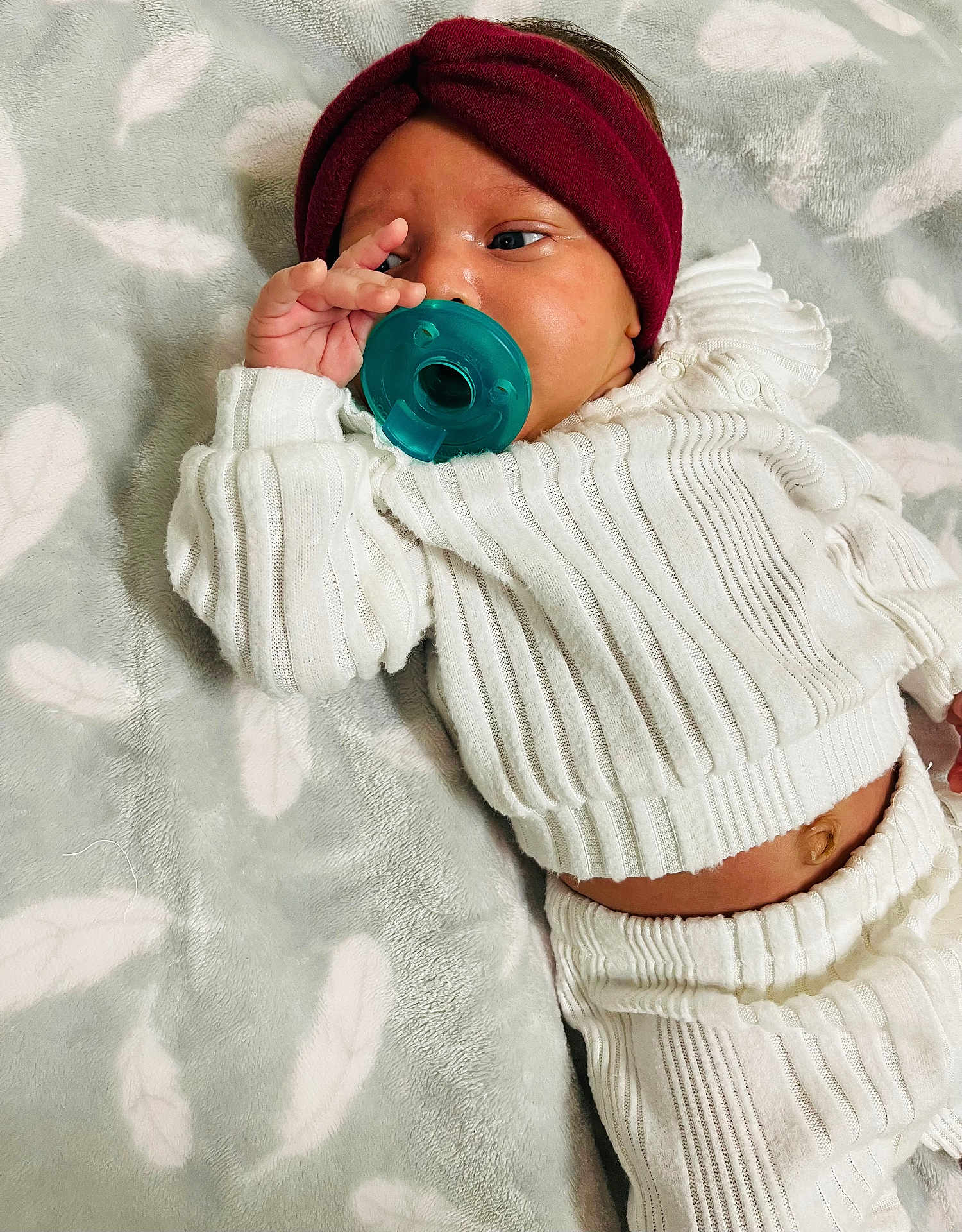 Abria joined the competition — help win amazing prizes! baby, blanket, child, comfortable, cute, face, feather_pattern, hand, headband, indoor, infant, knitted_outfit, lying_down, newborn, pacifier, portrait, relaxed, sleepwear, soft_texture, white_clothing