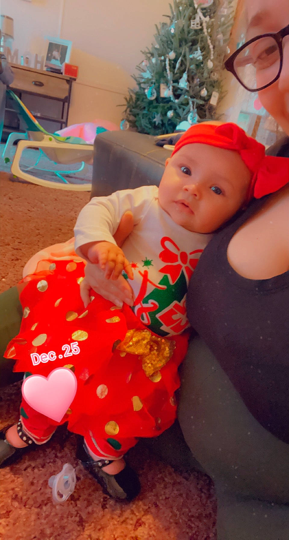 Nalani is registered to the contest to win money with this photo: abdomen, baby, baby_products, baby_toddler_clothing, child, christmas, christmas_decoration, christmas_eve, christmas_ornament, christmas_tree, costume_accessory, foot, headwear, holiday, holiday_ornament, human, lap, ornament, peach, person