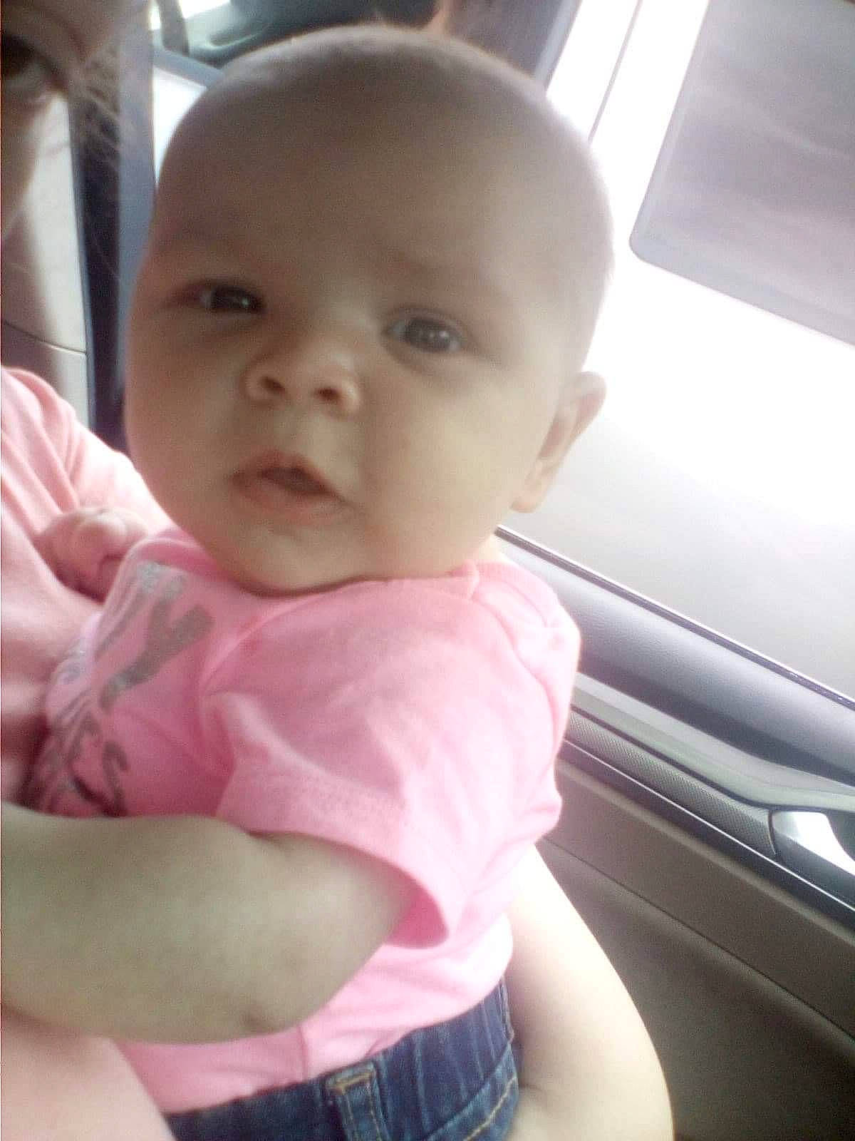 Nalani is registered to the contest to win money with this photo: baby, baby_toddler_clothing, car_seat, cheek, child, comfort, lip, person, pink, plaid, skin, stomach, tartan, toddler, vehicle_door