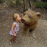 Mya a rejoint le concours — aidez-le/la à gagner de superbes lots ! child, toddler, dress, sandals, wooden_bear, sculpture, forest, trees, nature, outdoor, ground, rocks, plants, cute, interaction, playful, daylight, person, kissing, wood