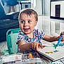 Mya a rejoint le concours — aidez-le/la à gagner de superbes lots ! toddler, child, drawing, markers, sketchbook, sitting, blue_eyes, floral_dress, indoor, living_room, furniture, table, chair, smiling, happy, person, art, coloring, floor, modern_decor