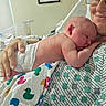 Matthew joined the competition — help win amazing prizes! newborn, baby, adult, hospital, blanket, duck_pattern, sleeping, smiling, glasses, hospital_gown, hand, portrait, indoor, person, tenderness, care, closeup, rest, infant, family