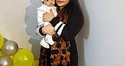 Arish joined the competition — help win amazing prizes! baby, balloons, birthday, celebration, child, family, hat, home, indoors, infant, mother, party_banner, portrait, scarf, silver_balloons, smiling, standing, winter_clothing, woman, yellow_balloons