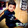 Arish is registered to the contest to win money with this photo: black_clothing, boy, child, eyes, face, fashion, hair, indoor, portrait, rebook_logo, shoe_boxes, shoe_store, shoes, shopping, sitting, smiling, sneakers, toddler, tracksuit, wooden_floor
