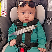 Liam is registered to the contest to win money with this photo: accessory, baby, baby_boy, baby_girl, car_seat, child, close_up, comfort, cute, headwear, indoors, infant, pacifier_clip, portrait, safety_harness, seat, seatbelt, serious_expression, sunglasses, teal_clothing