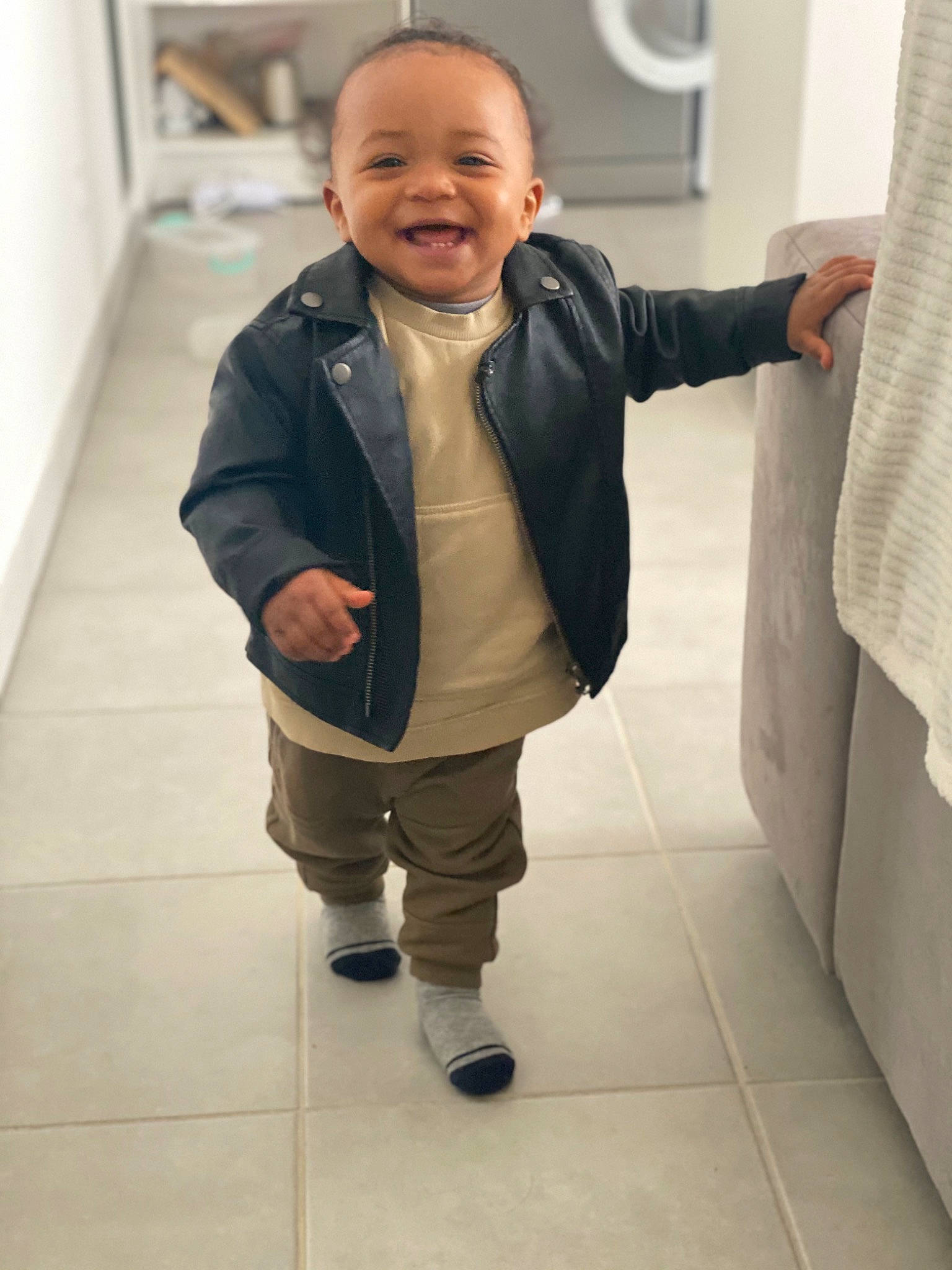 Kassim a rejoint le concours — aidez-le/la à gagner de superbes lots ! baby, baby_toddler_clothing, cheek, child, collar, eye, face, floor, flooring, formal_wear, gesture, happy, jacket, joy, leg, person, sleeve, smile, standing, suit